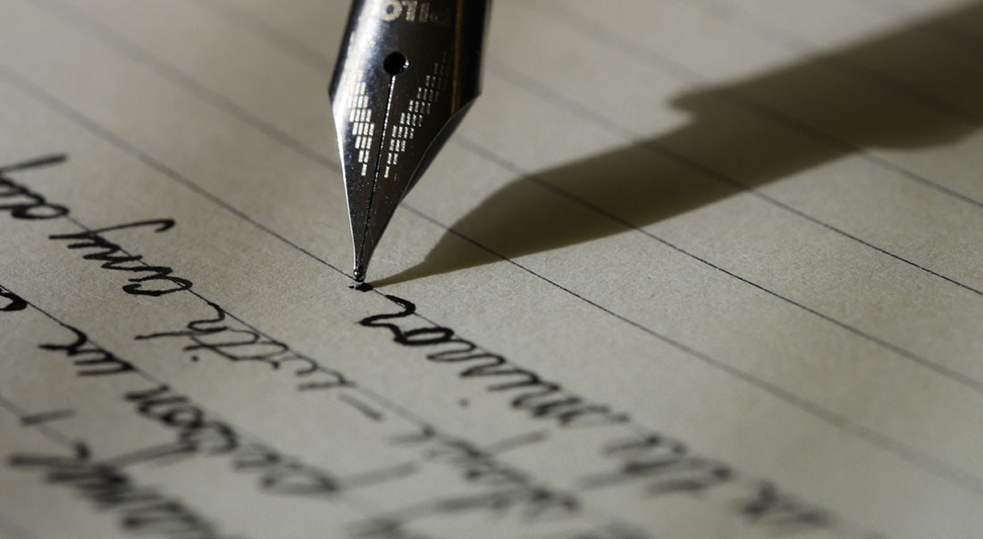 close up of fountain pen writing on paper