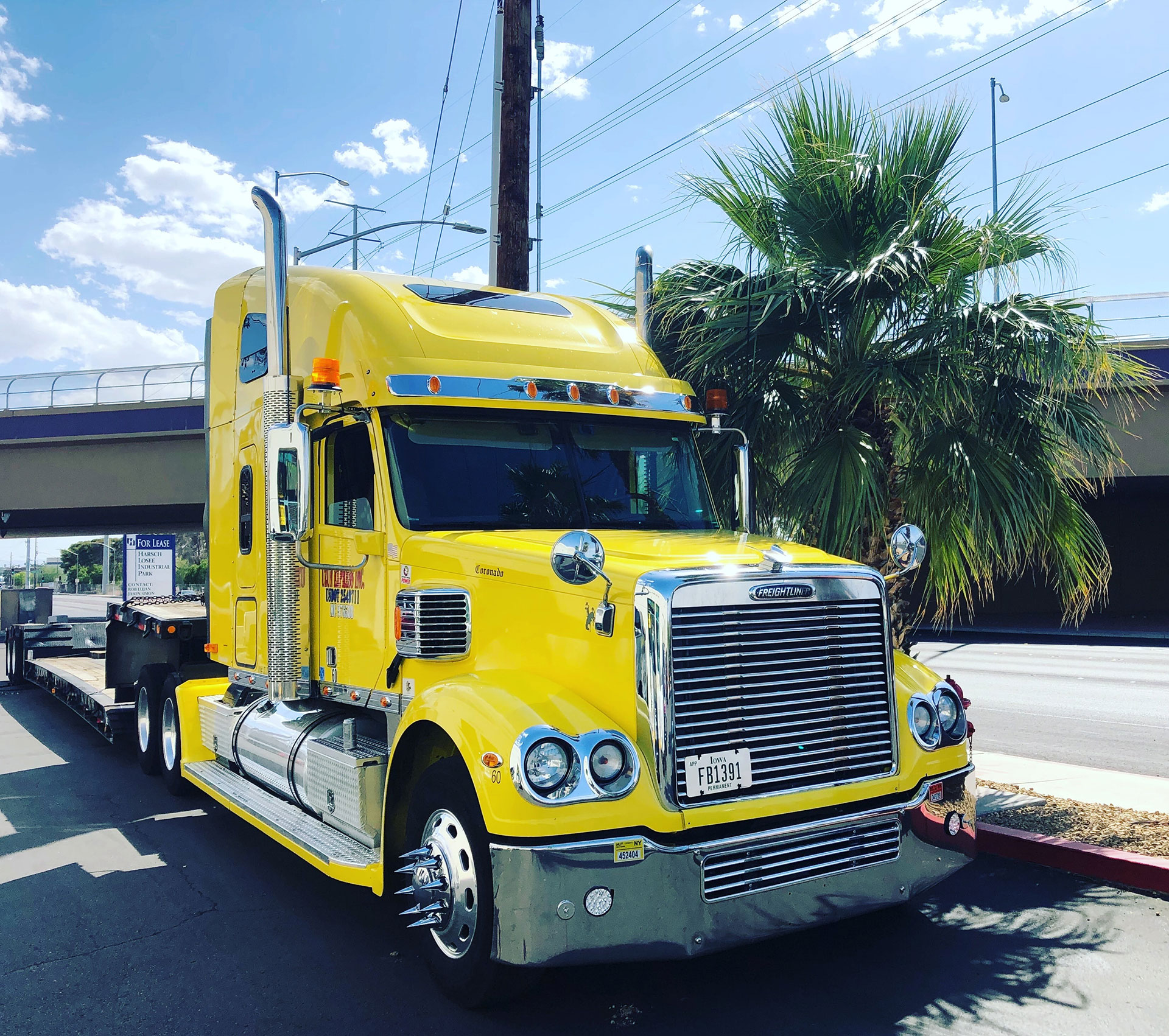 bright yellow semi-truck cab driving on road