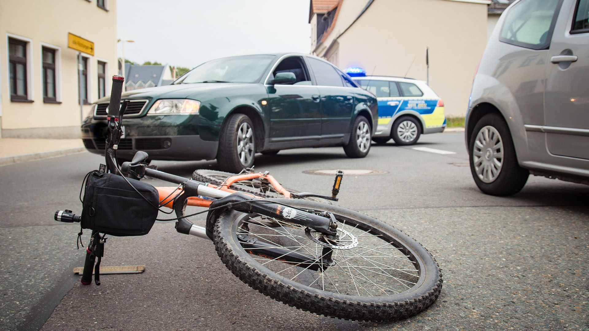 Bicycle Laying on Ground by Cars