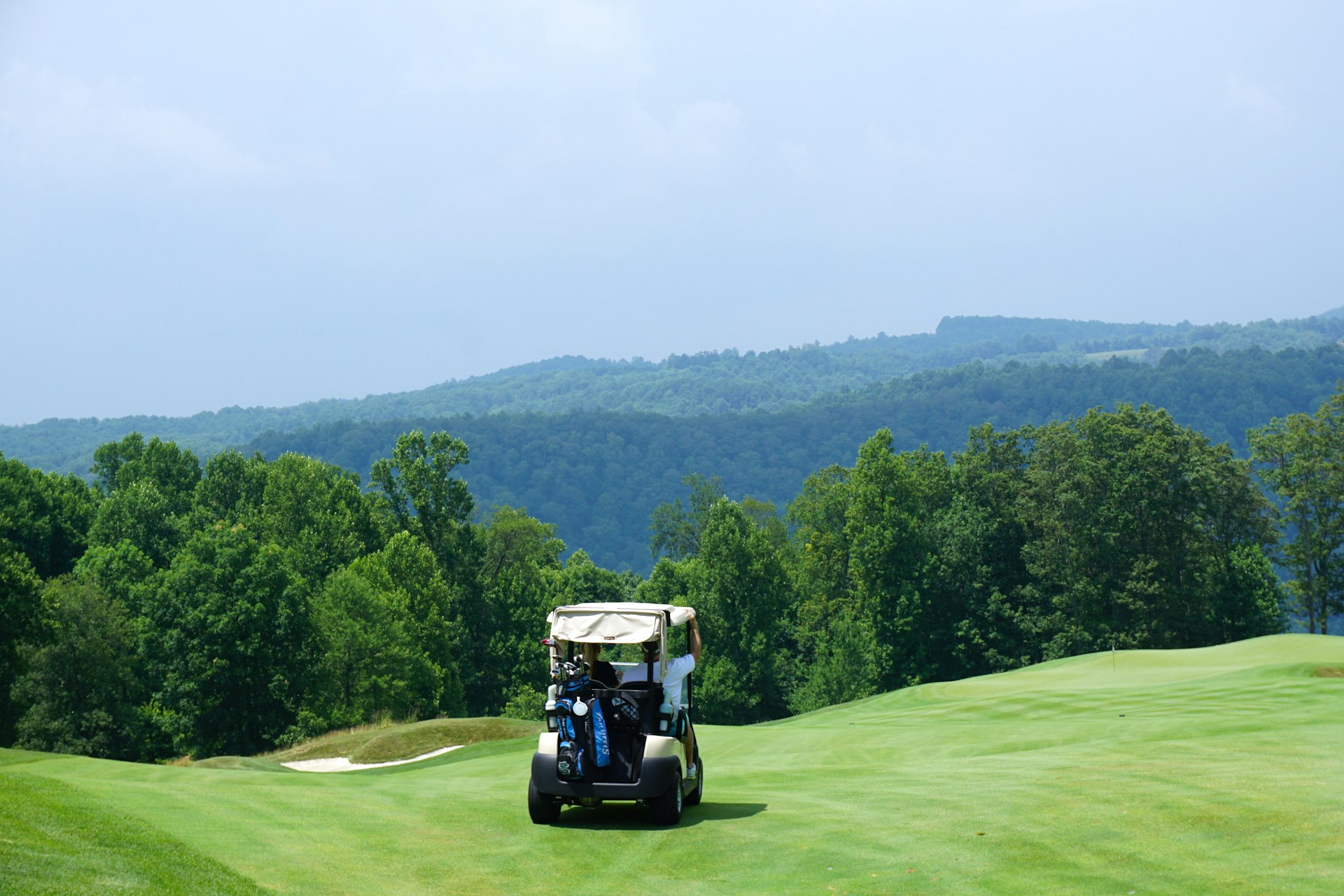 Two people riding a golf cart